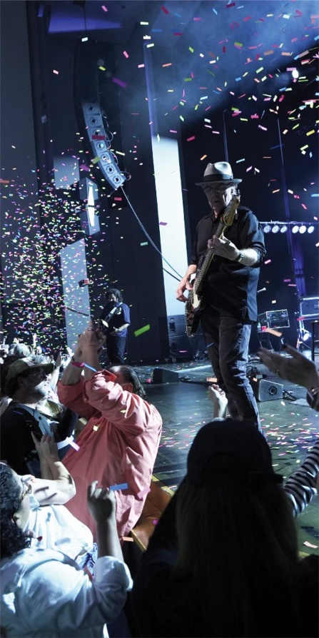 10,000 maniacs performing on stage while confetti falls around them.