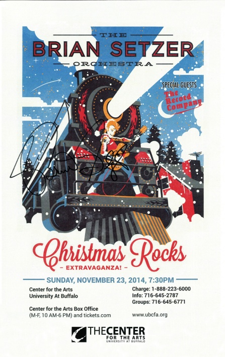drawing of a christmas themed train shining its headlight with a man holding a guitar in the front.