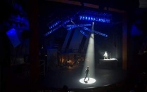 Spotlight on lone student on dark stage. 