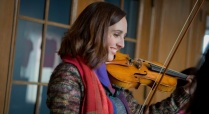 Woman with violin on her shoulder. 