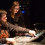 Two students working at a sound board. 