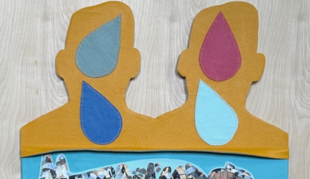 Leather cutout of two heads with different colored teardrops on top of them. 