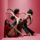 dancers posing up against a corner of a room. 
