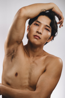 bilgude ariunbold posing without a shirt with one arm across body and one above head. 