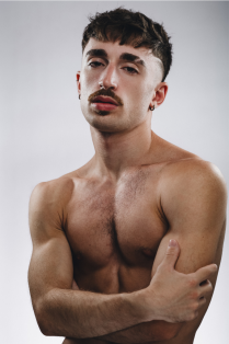 manuel vaccaro posing without a shirt on with arms folded across body. 