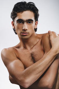 aristotle luna posing without a shirt on with arms across body. 