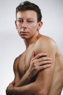 jordan beasley without a shirt on with arms across body. 