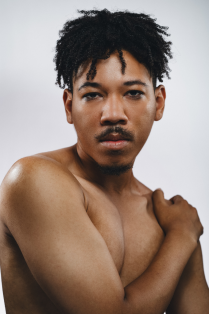 aeron buchanan without a shirt on with arms across body. 