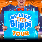 blippi holding a sign of the event in front of a cartoon stage. 