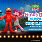 Elmo, Cookie Monster, and Abby standing on the stage and waving in front of a backdrop of a bridge. 