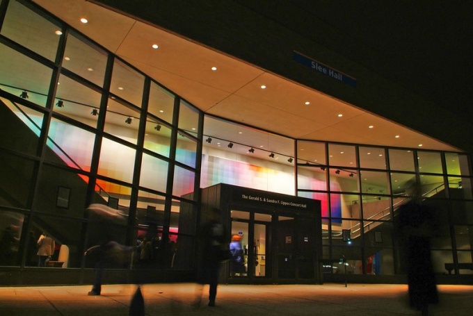exterior of slee hall at night. 