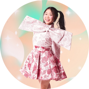 Ally Choe smiling and wearing a dress with a large bow.