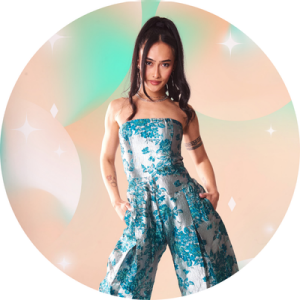 Emily posing in a pants dress with hands in pockets.