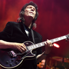Steve Hackett playing guitar on stage with eyes closed head raised. 