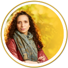 portait of Ella Al-Shamahi crossing her arms and wearing a scarf. 