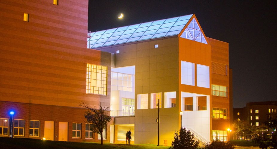 Exterior of rear entrance of well-lit CFA building at night. 